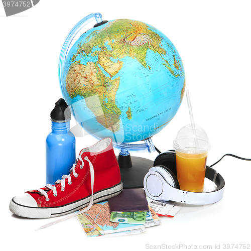 Image of The blue globe, sneakers, thermos and headphones on white background.