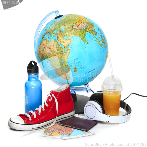 Image of The blue globe, sneakers, thermos and headphones on white background.