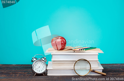 Image of Back to School concept. Books, colored pencils and clock