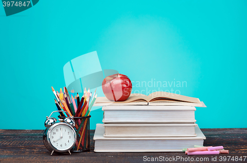 Image of Back to School concept. Books, colored pencils and clock