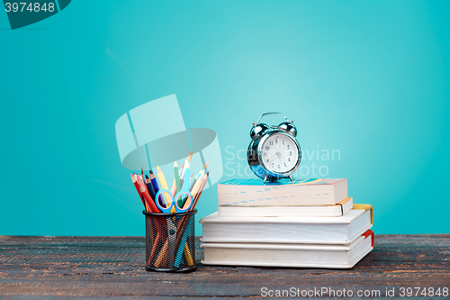 Image of Back to School concept. Books, colored pencils and clock