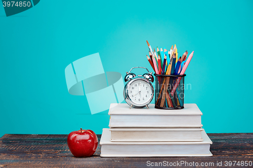 Image of Back to School concept. Books, colored pencils and clock