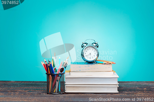 Image of Back to School concept. Books, colored pencils and clock
