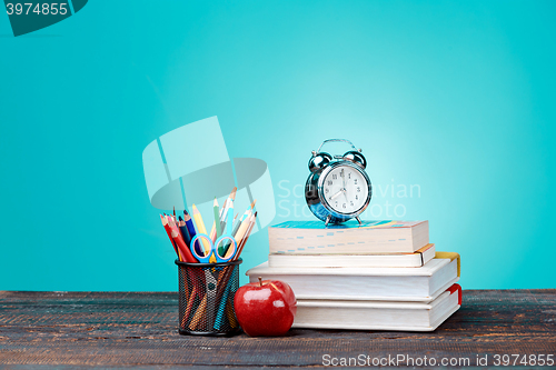 Image of Back to School concept. Books, colored pencils and clock