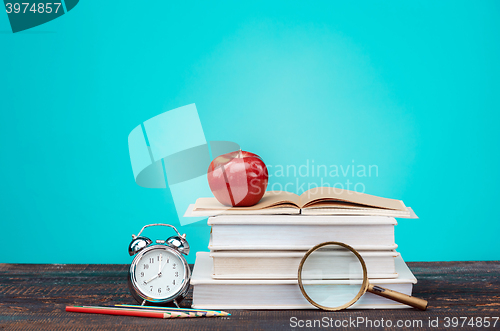 Image of Back to School concept. Books, colored pencils and clock