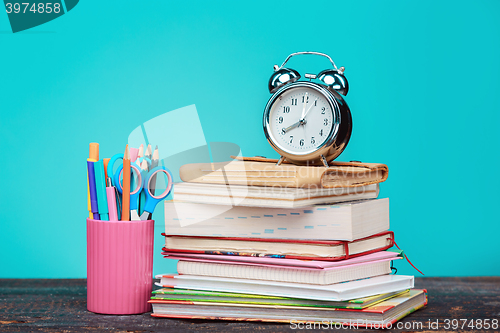 Image of Back to School concept. Books, colored pencils and clock