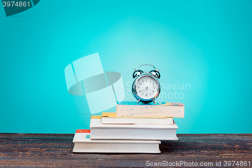 Image of Back to School concept. Books, colored pencils and clock