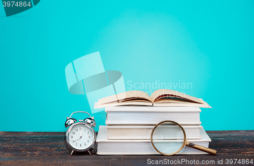 Image of Back to School concept. Books, colored pencils and clock