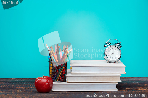 Image of Back to School concept. Books, colored pencils and clock