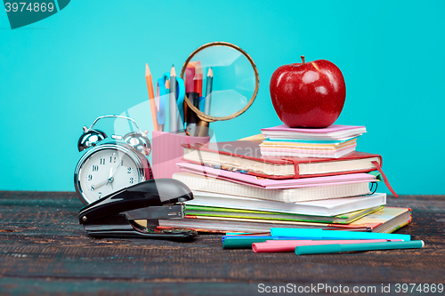 Image of Back to School concept. Books, colored pencils and clock