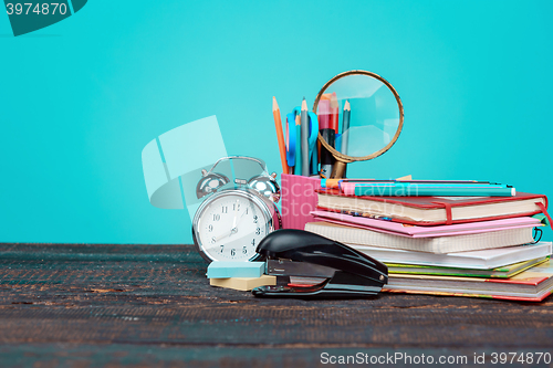 Image of Back to School concept. Books, colored pencils and clock