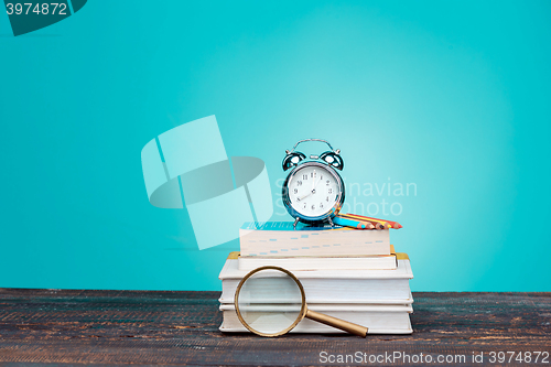 Image of Back to School concept. Books, colored pencils and clock