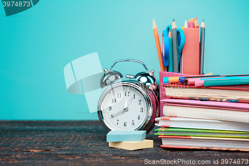 Image of Back to School concept. Books, colored pencils and clock