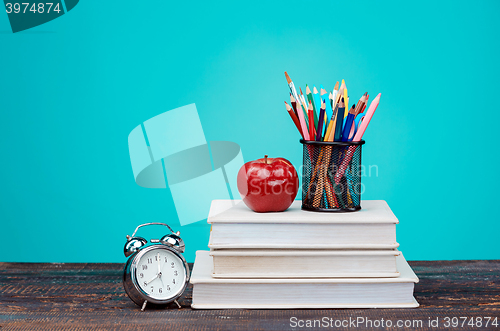 Image of Back to School concept. Books, colored pencils and clock