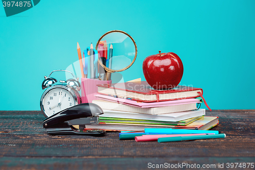 Image of Back to School concept. Books, colored pencils and clock