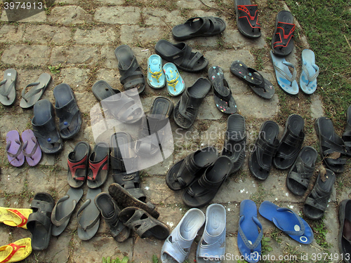 Image of Shoes in front of the Catholic Church in India in all the temples enters barefoot