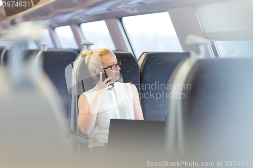 Image of Business woman working while travelling by train.