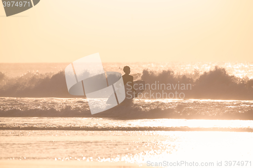 Image of Surfers on beach with surfboard.