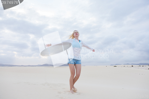 Image of Carefree woman enjoying freedom on beach.