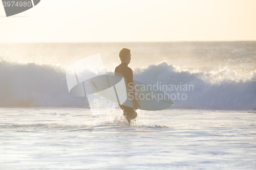 Image of Surfers on beach with surfboard.