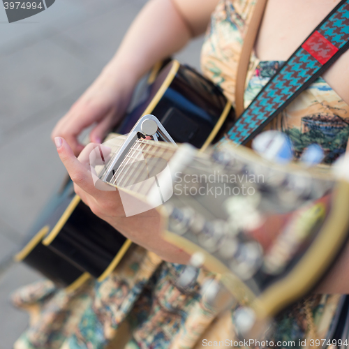 Image of Female street musician playing guitar.