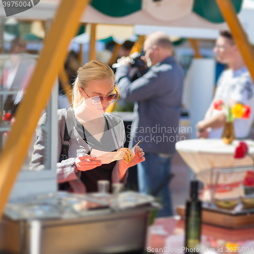 Image of Woman buying meal at street food festival.