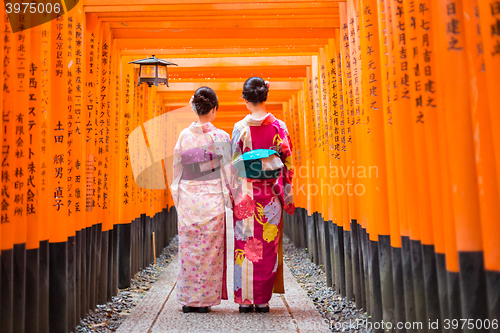 Image of Geishas among red wooden Tori Gate at Fushimi Inari Shrine in Kyoto, Japan