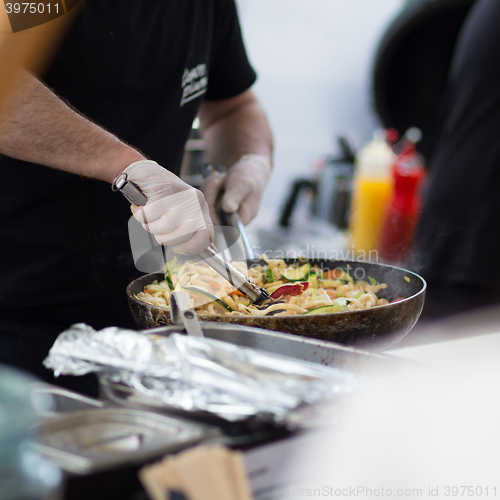 Image of Cheff cooking on outdoor street food festival.