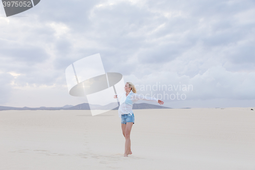 Image of Carefree woman enjoying freedom on beach.