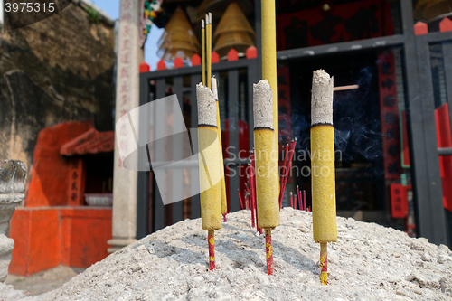 Image of Three burning incense in front of Chinese temple