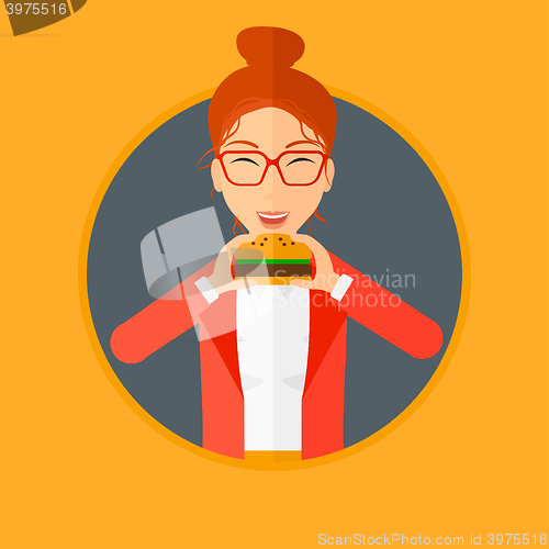 Image of Woman eating hamburger.