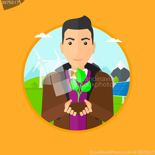 Image of Man holding green small plant.