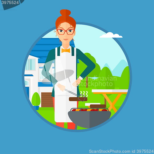 Image of Woman cooking meat on barbecue grill.