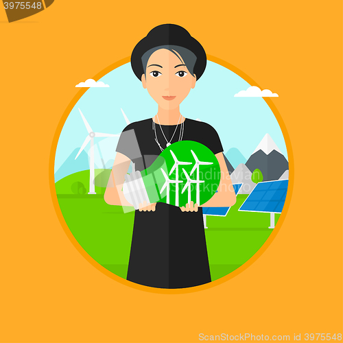 Image of Woman holding lightbulb with wind turbines inside.