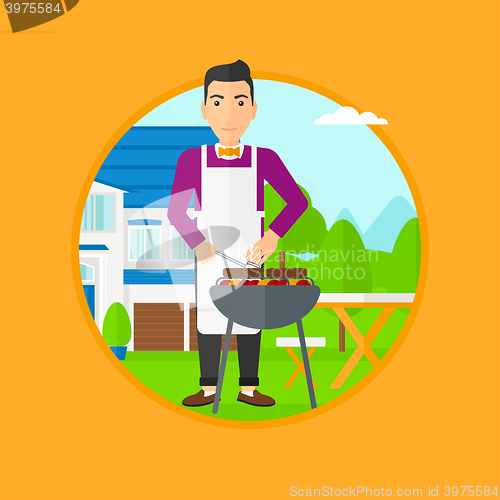 Image of Man cooking meat on barbecue grill.