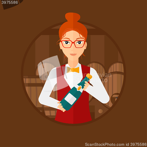 Image of Waitress holding bottle in wine cellar.