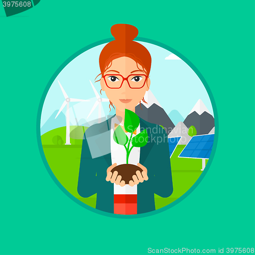 Image of Woman holding green small plant.