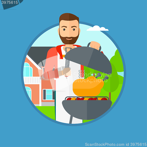 Image of Man cooking chicken on barbecue grill.