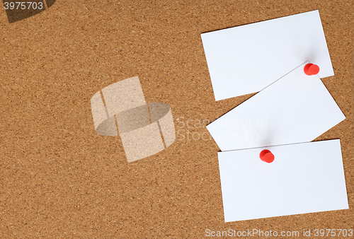 Image of Cork board with three white cards pinned to it