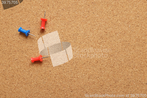 Image of Three push pins on a cork noticeboard