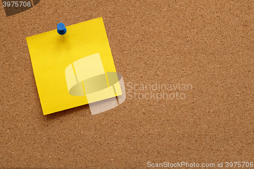 Image of Yellow note paper pinned to a cork board