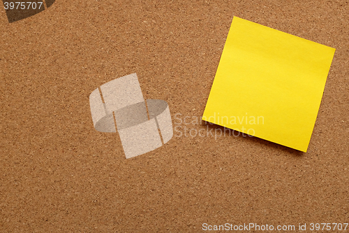 Image of Yellow sticky note stuck on cork board