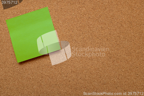 Image of Blank green note paper stuck on cork board