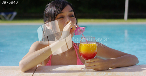 Image of Happy smiling young woman with a fruity cocktail