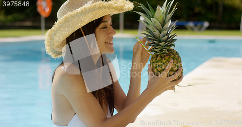 Image of Young woman sipping a pineapple cocktail