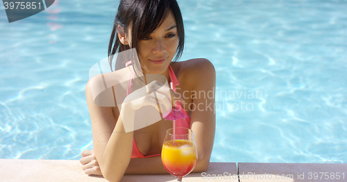 Image of Pretty young woman sipping a tropical cocktail