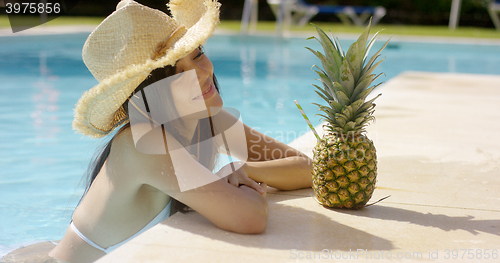 Image of Pretty trendy young woman in a summer pool