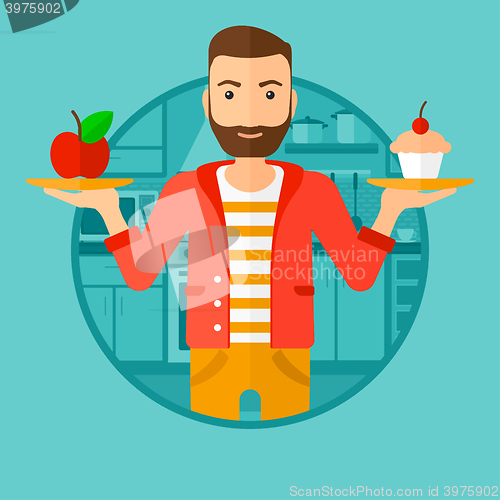 Image of Man choosing between apple and cupcake.