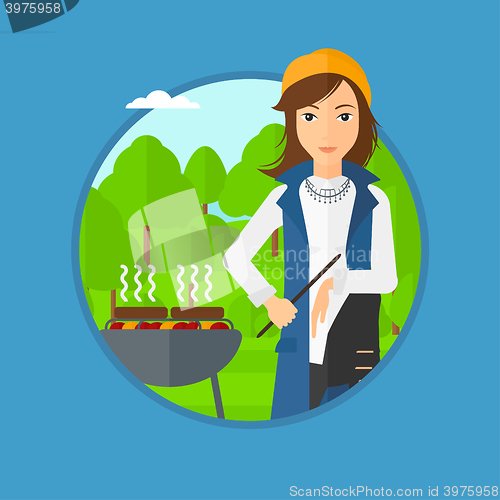 Image of Woman cooking meat on barbecue.