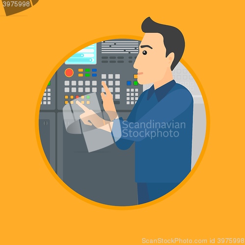 Image of Engineer standing near control panel.